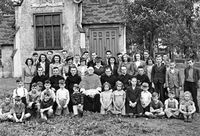 Le cur&eacute; Godbout entour&eacute; des membres et des enfants de l'O.T.J.
